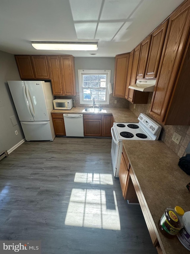 kitchen featuring tasteful backsplash, sink, white appliances, and light wood-type flooring