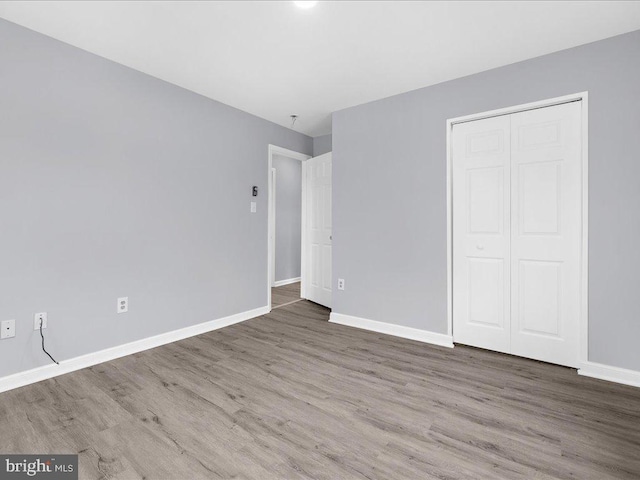 unfurnished bedroom with hardwood / wood-style floors and a closet