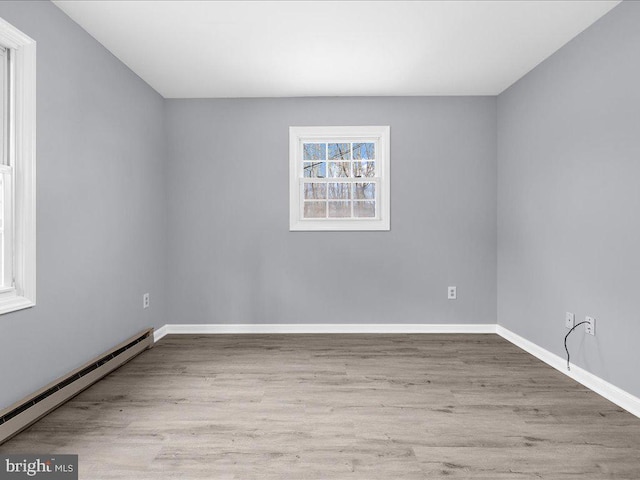 unfurnished room with light hardwood / wood-style flooring and baseboard heating