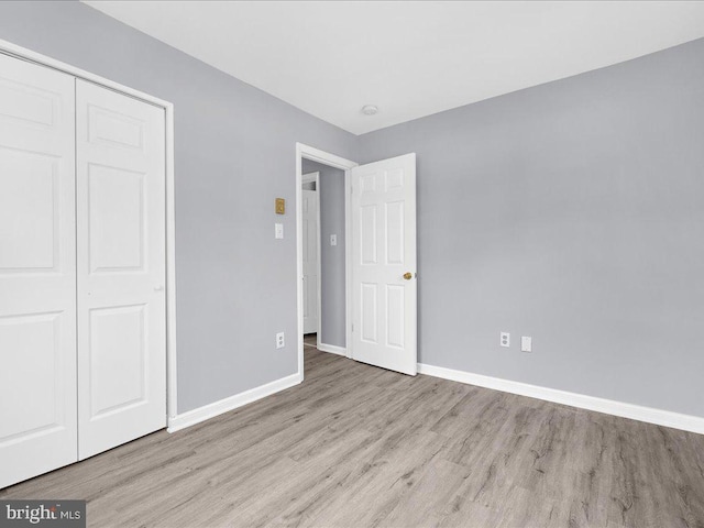 unfurnished bedroom with light hardwood / wood-style floors and a closet