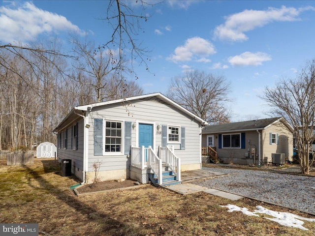 view of front facade with cooling unit and a storage shed