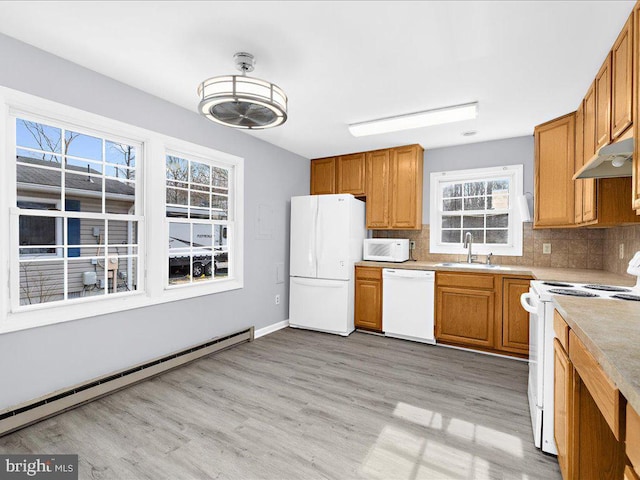 kitchen with sink, white appliances, light hardwood / wood-style flooring, baseboard heating, and decorative backsplash