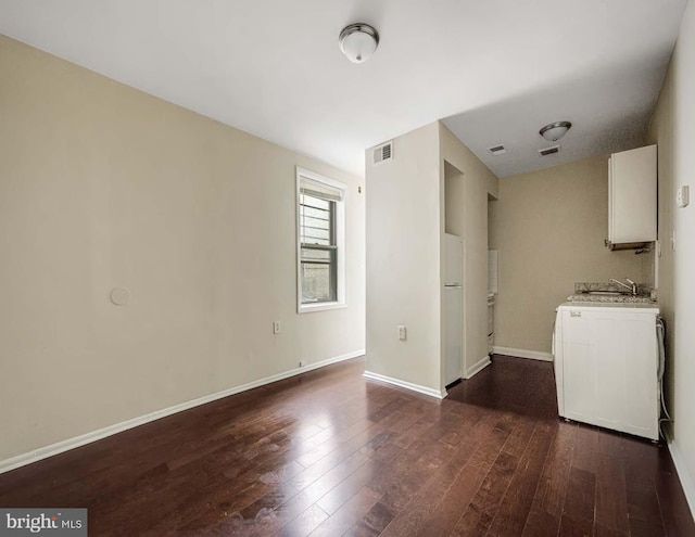 interior space featuring dark wood-type flooring, cabinets, and sink