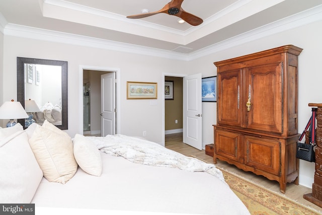 bedroom featuring ceiling fan, ornamental molding, a raised ceiling, and light hardwood / wood-style flooring