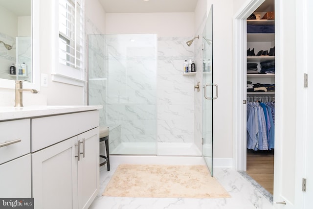 bathroom featuring walk in shower and vanity