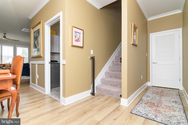 entryway with crown molding, ceiling fan, and light wood-type flooring