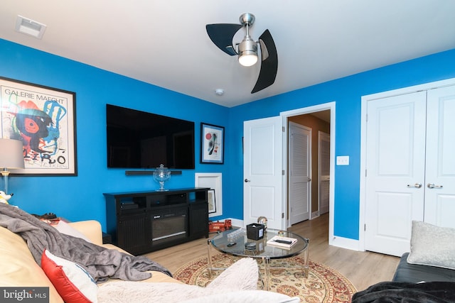 living room featuring ceiling fan and light hardwood / wood-style flooring