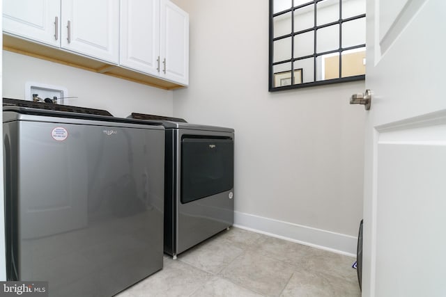 laundry room with cabinets, washer and dryer, and light tile patterned floors