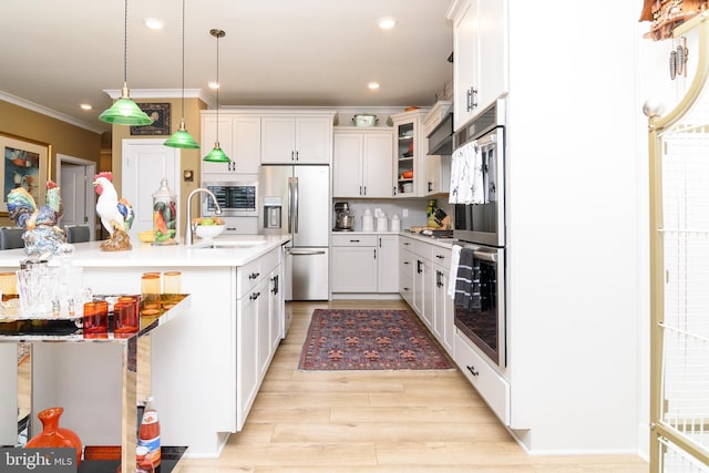 kitchen with white cabinetry, tasteful backsplash, ornamental molding, pendant lighting, and stainless steel appliances