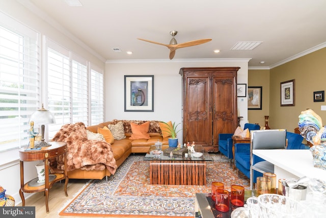 living room featuring ceiling fan, ornamental molding, and light hardwood / wood-style flooring