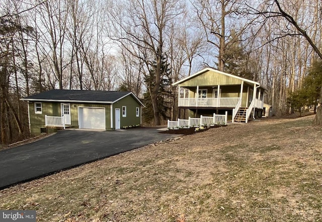 view of front of property featuring driveway, covered porch, and an attached garage