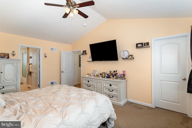 bedroom with vaulted ceiling, light colored carpet, ceiling fan, and ensuite bathroom