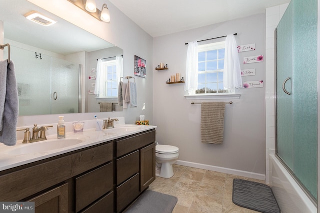 full bathroom featuring vanity, combined bath / shower with glass door, and toilet