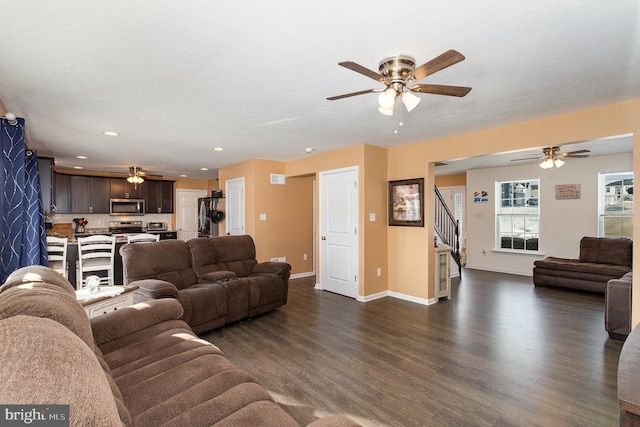 living room featuring dark wood-type flooring and ceiling fan