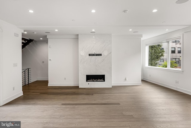 unfurnished living room featuring hardwood / wood-style floors and a premium fireplace