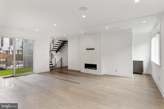 unfurnished living room with a fireplace and light hardwood / wood-style flooring