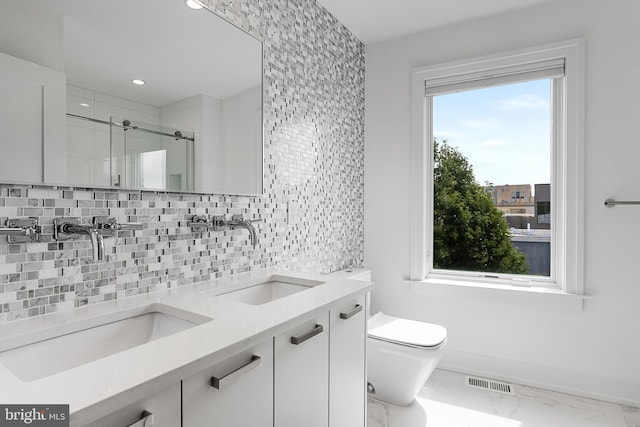 bathroom featuring vanity, decorative backsplash, a shower with door, and toilet