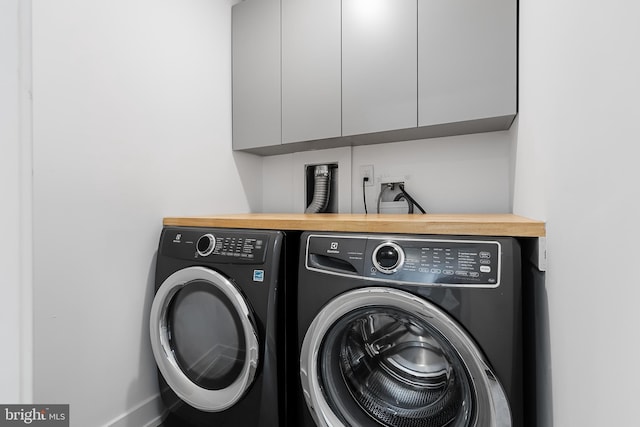 washroom with cabinets and washer and dryer