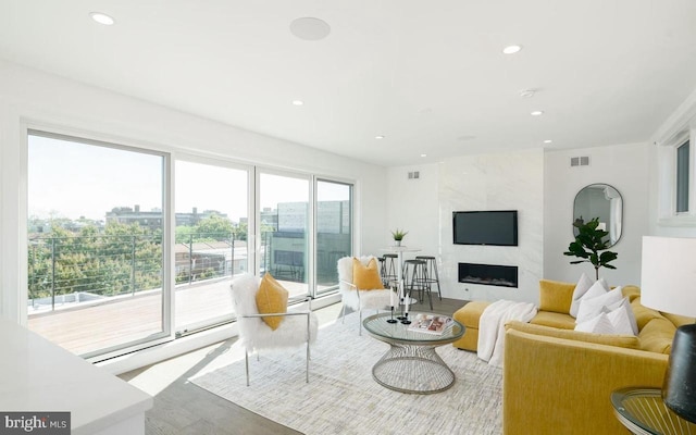 living room with hardwood / wood-style flooring, a high end fireplace, and baseboard heating