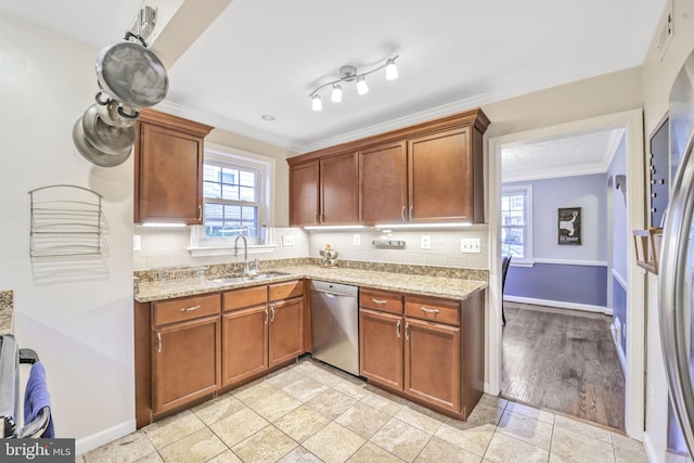 kitchen with decorative backsplash, appliances with stainless steel finishes, light stone counters, crown molding, and a sink