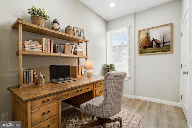 home office with light hardwood / wood-style flooring