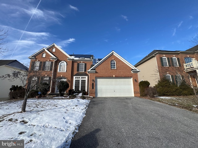 view of front property featuring a garage and solar panels