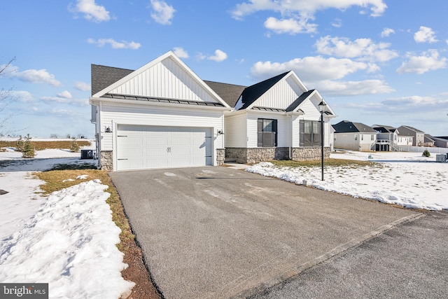 view of front of home featuring a garage and central air condition unit