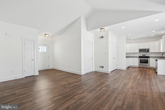 unfurnished living room featuring lofted ceiling and dark hardwood / wood-style flooring