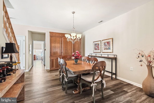 dining area featuring dark wood-type flooring and a notable chandelier