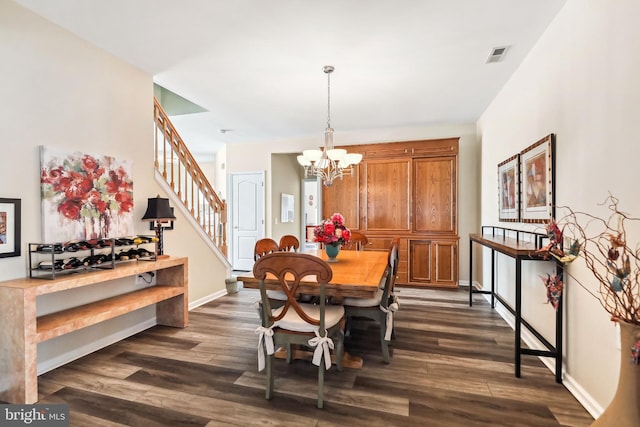 dining space with dark wood-type flooring and a notable chandelier