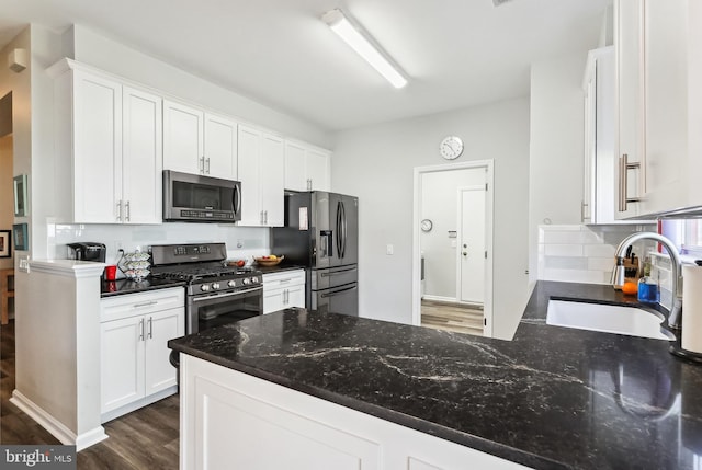 kitchen featuring sink, appliances with stainless steel finishes, white cabinetry, backsplash, and dark hardwood / wood-style flooring