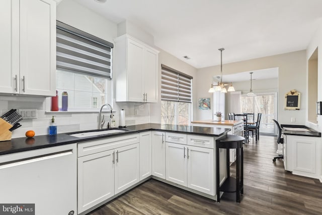 kitchen with dishwashing machine, sink, kitchen peninsula, and white cabinets