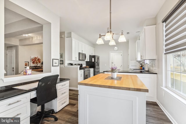 kitchen featuring stainless steel appliances, white cabinetry, and a center island