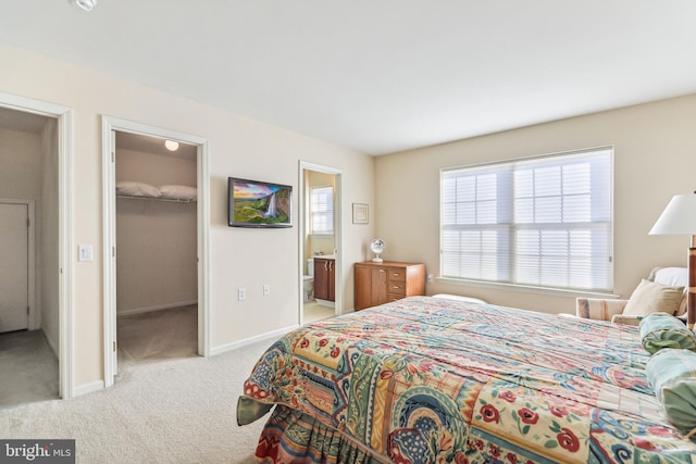 carpeted bedroom with ensuite bath, a spacious closet, and a closet