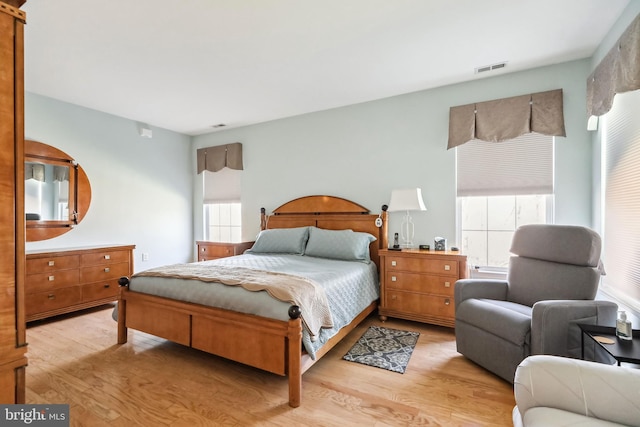 bedroom with multiple windows and light hardwood / wood-style floors