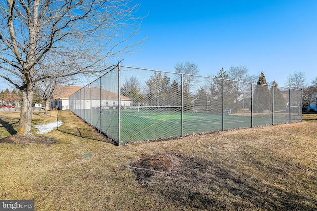 view of tennis court with a yard