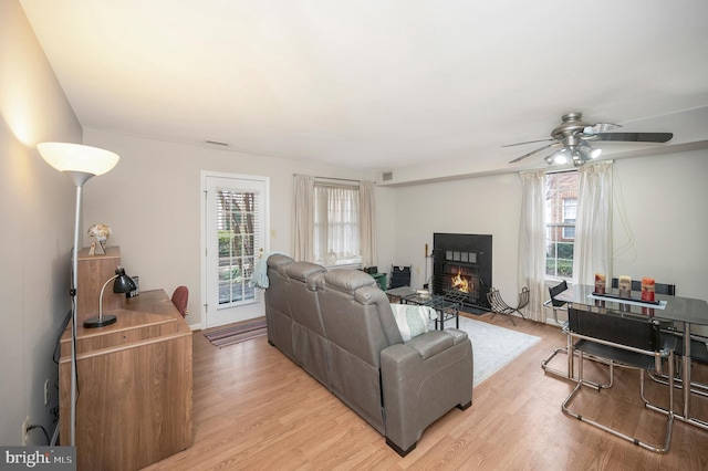 living room featuring ceiling fan, light hardwood / wood-style floors, and a wealth of natural light