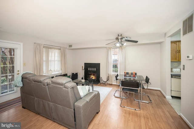 living room featuring ceiling fan, plenty of natural light, and wood-type flooring