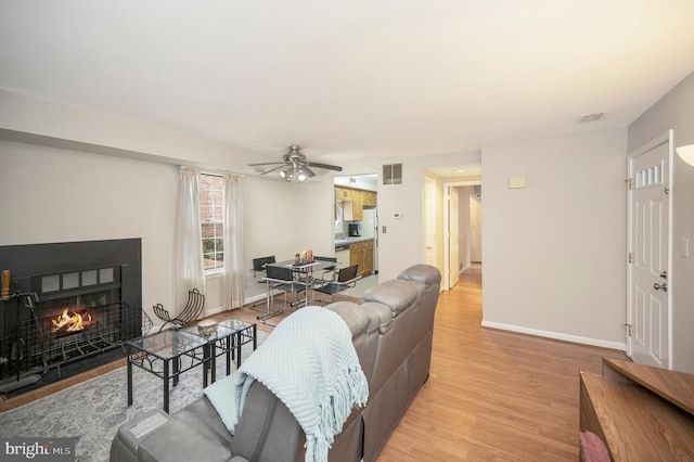 living room with ceiling fan and light hardwood / wood-style floors