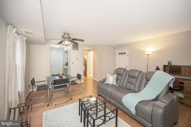 living room with ceiling fan and light wood-type flooring