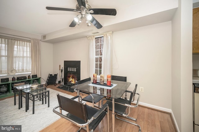 dining space with ceiling fan and light hardwood / wood-style floors