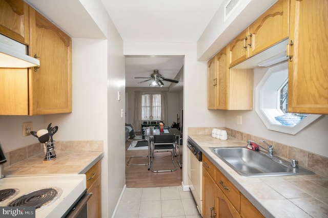 kitchen featuring light tile patterned flooring, dishwasher, sink, electric range, and ceiling fan