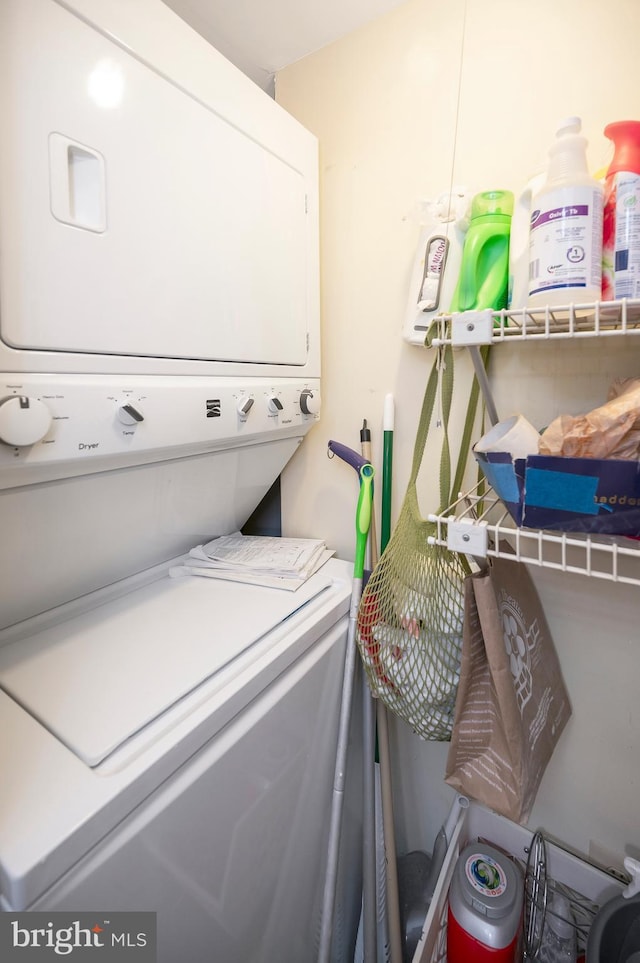 clothes washing area with stacked washer and dryer