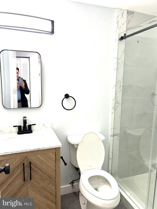 bathroom featuring walk in shower, vanity, and toilet