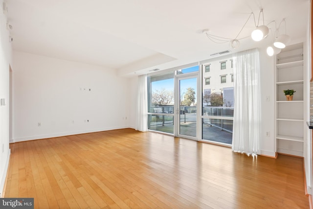 spare room featuring hardwood / wood-style flooring and expansive windows