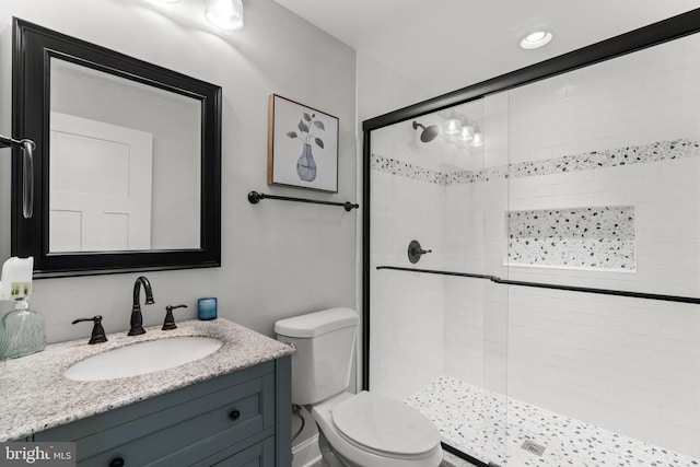 bathroom featuring vanity, an enclosed shower, and toilet