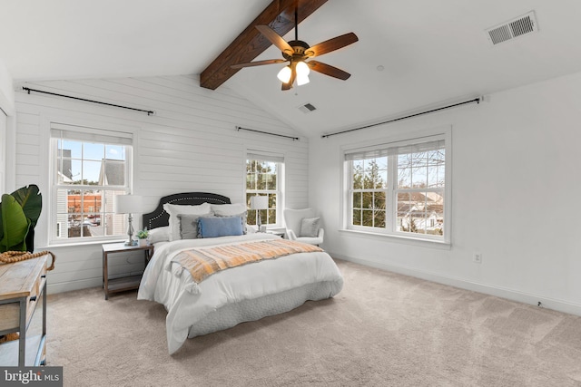 carpeted bedroom with ceiling fan and vaulted ceiling with beams