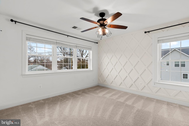 carpeted empty room featuring a wealth of natural light and ceiling fan