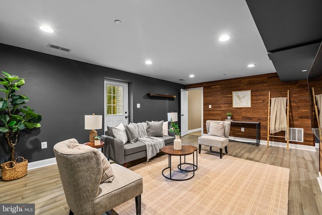 living room featuring wooden walls and light wood-type flooring