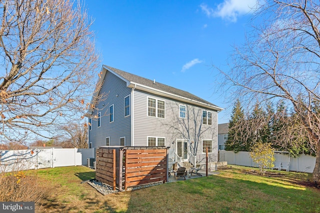 rear view of property featuring central AC unit and a yard